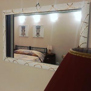 einen Spiegel in einem Schlafzimmer mit einem Bett darin in der Unterkunft San Nicolò House in Aci Catena