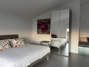 sypialnia z białym łóżkiem i lustrem w obiekcie Il Mare di Giù Boutique Guesthouse w mieście Licata