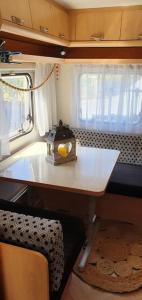 een kleine keuken met een tafel in een camper bij insolite: la p'tite maison à roulettes in Jalhay