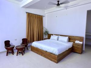 a bedroom with a large bed and two chairs at cozy room with no restrictions in Gurgaon