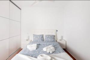 a white bedroom with a bed with towels on it at El Balcón De Arinaga in Agüimes