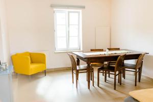 a dining room with a table and a yellow chair at Tauglerei Doppelzimmer Bergamotte in Sankt Koloman