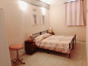 1 dormitorio con cama, mesa y taburete en San Nicolò House en Aci Catena