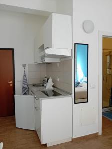 a kitchen with white cabinets and a sink and a mirror at Via Guido Panciroli il guscio in Reggio Emilia