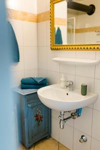 a bathroom with a sink and a mirror at Tauglerei Appartement Enzian in den Zauberbergen in Sankt Koloman
