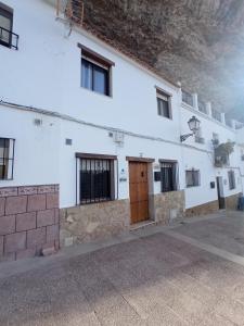 ein weißes Gebäude mit einer Holztür darauf in der Unterkunft LAS CALAÑAS DE SETENIL in Setenil de las Bodegas