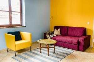 Una sala de estar con un sofá, una mesa y una silla. en Tauglerei Appartement Enzian in den Zauberbergen, en Sankt Koloman