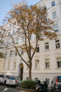 a white building with a tree in front of it at Cozy APT perfect for 4-6 TV Metro Self-Checkin in Vienna