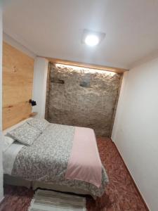 ein Schlafzimmer mit einem Bett und einer Ziegelwand in der Unterkunft LAS CALAÑAS DE SETENIL in Setenil de las Bodegas