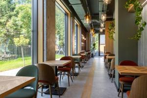 a row of tables and chairs in a restaurant with windows at XYZ eXtreme You Zen in Szczyrk