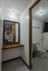 a bathroom with a mirror and a toilet at Marion Hotel in Manila