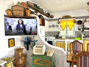 a kitchen with a tv on a wall in a room at El houch الحوش in Port El Kantaoui