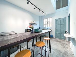 a kitchen with a wooden counter and stools at HUKM CoLiving 21 by Manhattan Group in Kuala Lumpur