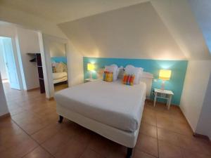 a bedroom with a large white bed with two lamps at Village vacances appartement 3 pièces - 1 à 6 personnes - vue mer & calme in Sainte-Luce