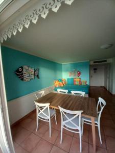 a dining room with a table and chairs and a couch at Village vacances appartement 3 pièces - 1 à 6 personnes - vue mer & calme in Sainte-Luce