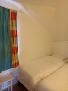 a room with two beds and a window with a curtain at Village vacances appartement 3 pièces - 1 à 6 personnes - vue mer & calme in Sainte-Luce