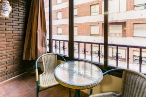 una mesa y sillas en un balcón con ventana en Gran Apartamento en el centro con Parking Gratis, en Córdoba