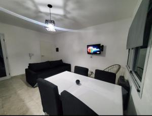 sala de estar con mesa blanca y sofá en Travel Suites Ezeiza en Ezeiza