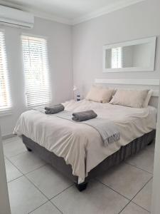 a large bed in a white room with windows at Sea la Vie 12 Bridge in St Lucia