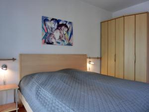 1 dormitorio con 1 cama y una pintura en la pared en Ferienwohnung D3, en Graal-Müritz