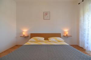 sypialnia z łóżkiem z 2 poduszkami i 2 lampami w obiekcie House Slavko 2297 w mieście Grandići