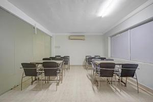 a room with tables and chairs and a white wall at Comfort Park Inn (Unit of Prohotel) in Chennai