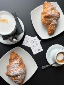 a table with two plates of pastries and a cup of coffee at Casa Bella in Ponti Sul Mincio