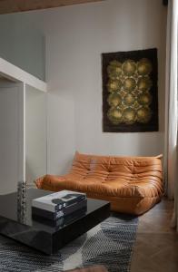 een woonkamer met een bruine leren bank en een schilderij bij MiHotel Serlin in Lyon