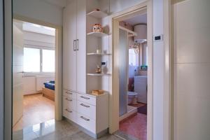 ein Badezimmer mit weißen Schränken und einem Spiegel in der Unterkunft Apartment Kamnik-apartment with a large terrace in Kamnik