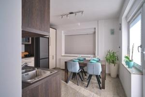 Apartment Kamnik-apartment with a large terrace في كامنيك: مطبخ مع طاولة وكراسي ومغسلة