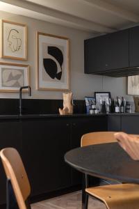 a kitchen with a black counter and a table at MiHotel Serlin in Lyon