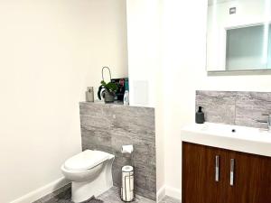 a bathroom with a toilet and a sink at Home from Homes in Bedford