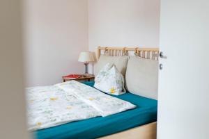1 dormitorio con 1 cama con sábanas y almohadas azules en Tauglerei Appartement Kamin in den Zauberbergen, en Sankt Koloman