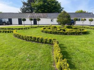 een tuin met struiken en een gebouw op de achtergrond bij Winstitchen Cottage situated near the River Barle in Simonsbath +64 foto's