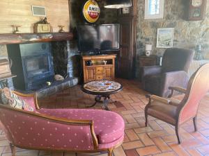 a living room with a tv and a couch and chairs at Chalet 09 in Albiès