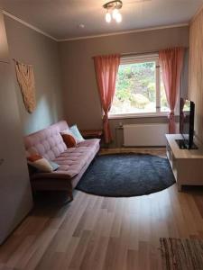 un soggiorno con divano rosa e finestra di Saunallinen yksiö, 4 vuodepaikka a Eura
