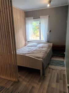 a bedroom with a bed and a window at Saunallinen yksiö, 4 vuodepaikka in Eura