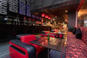 a restaurant with red chairs and a table and a bar at Galleria Sukhumvit 10 Bangkok by Compass Hospitality in Bangkok