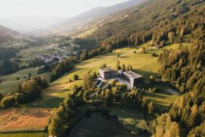 an aerial view of a house on a hill next to a lake at St Michael Alpin Retreat in Matrei am Brenner