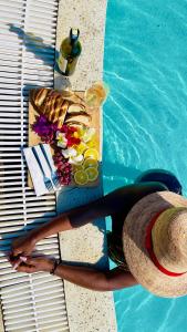 una donna seduta accanto a un tavolo accanto a una piscina di The hayce residence a Kilifi
