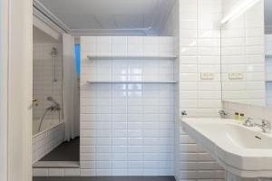 a white bathroom with a sink and a shower at Canela Homes BARCELONA MODERNISTA in Barcelona