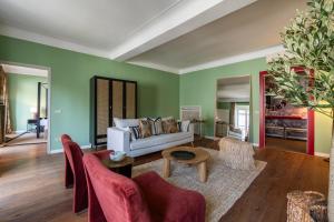 a living room with green walls and a white couch at Bagutta Suites - The Couper in Milan