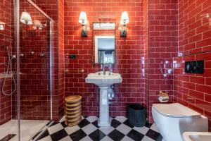 a bathroom with red brick walls and a sink and a toilet at Bagutta Suites - The Couper in Milan +45 photos