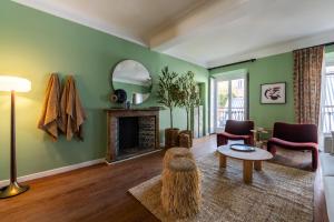 a living room with green walls and a fireplace at Bagutta Suites - The Couper in Milan