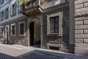 an entrance to a building with a balcony on a street at Bagutta Suites - The Couper in Milan