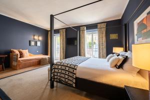 a bedroom with a large bed and a couch at Bagutta Suites - The Couper in Milan