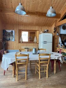 eine Küche mit einem Tisch mit Stühlen und einem Kühlschrank in der Unterkunft Chalet Familial in Matemale