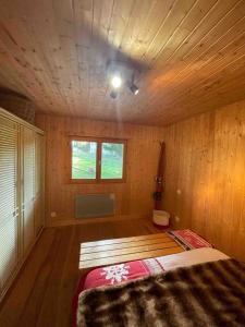 ein Schlafzimmer mit einem Bett in einem Holzzimmer in der Unterkunft Chalet Familial in Matemale