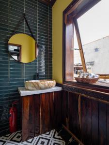 La salle de bains est pourvue d'un lavabo et d'une grande fenêtre. dans l'établissement Arabica coffee homestay, à Hội An