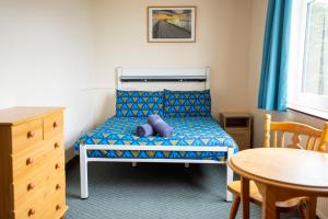 a small bedroom with a bed and a table at Inverness Youth Hostel in Inverness